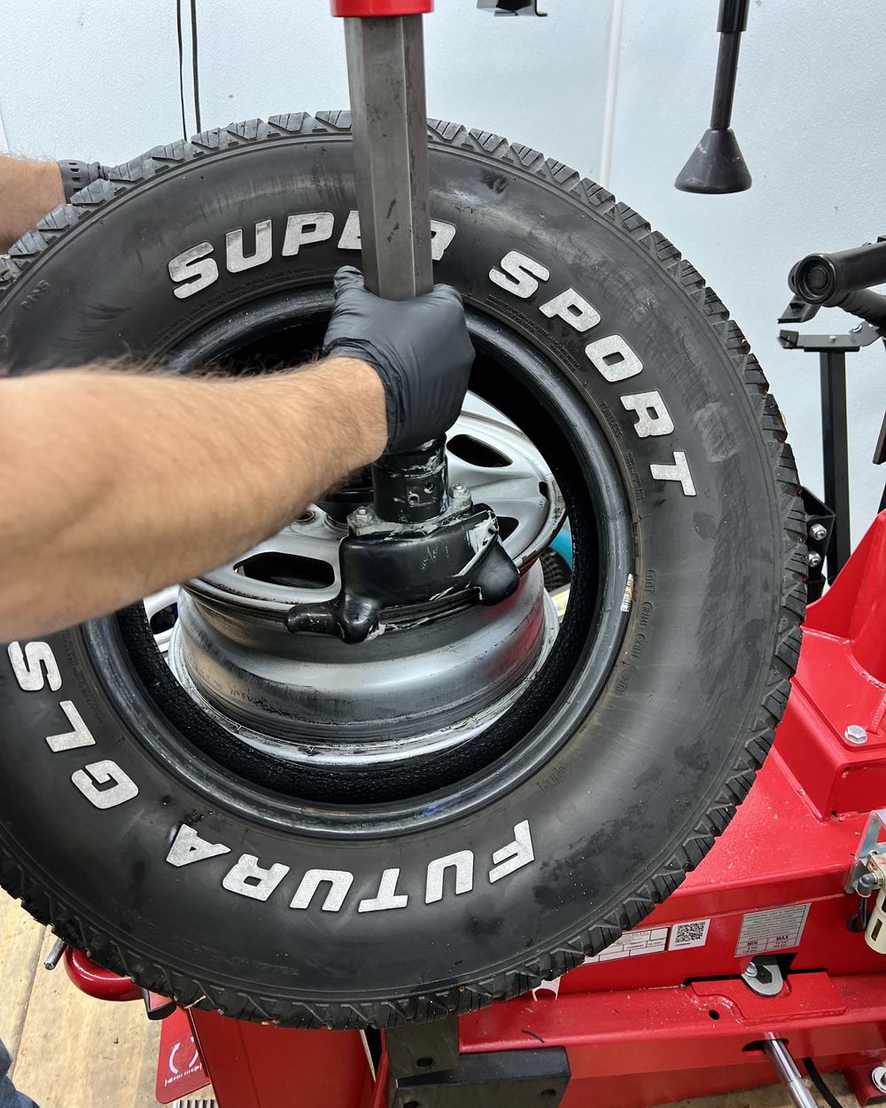 A tire being worked onto a steel wheel on the red tire changer